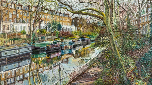 A tree-lined canal in London with traditional narrow boats and edged by townhouses which are reflecting in the water